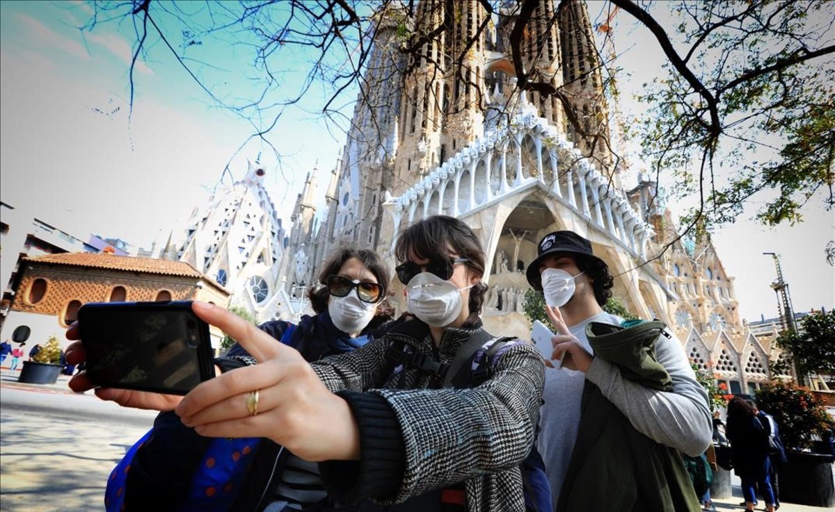 tres turistas hacen selfie con mascarillas