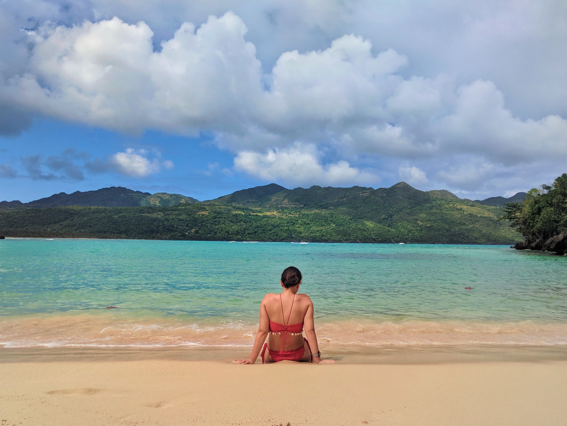 Dominicana, turista mujer en la playa, de espaldas