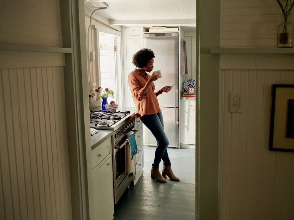 Airbnb, mujer en una cocina con su celular
