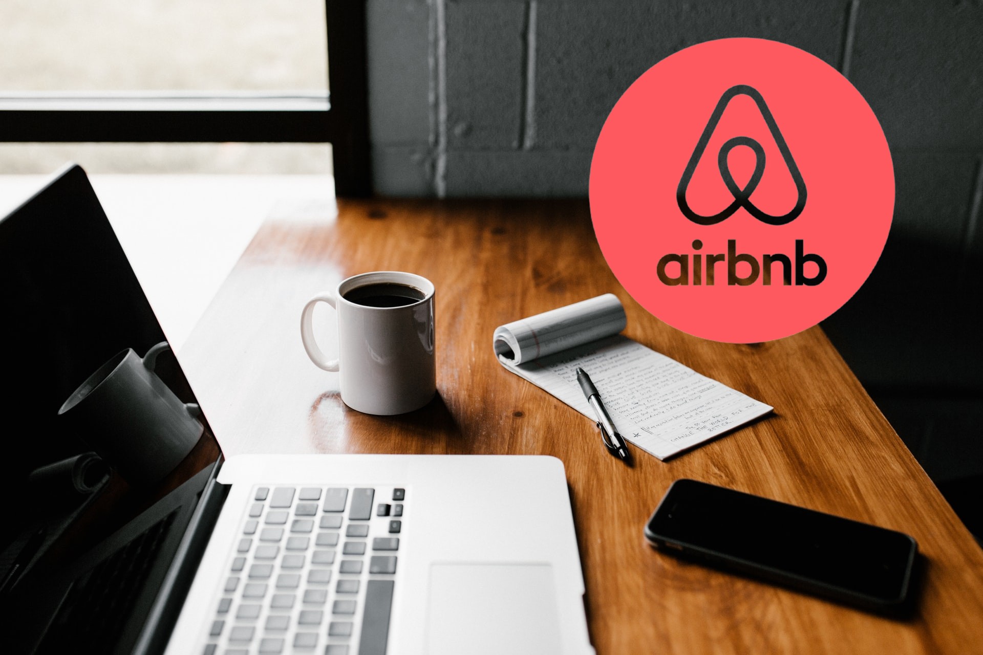 mesa de trabajo y logo de Airbnb