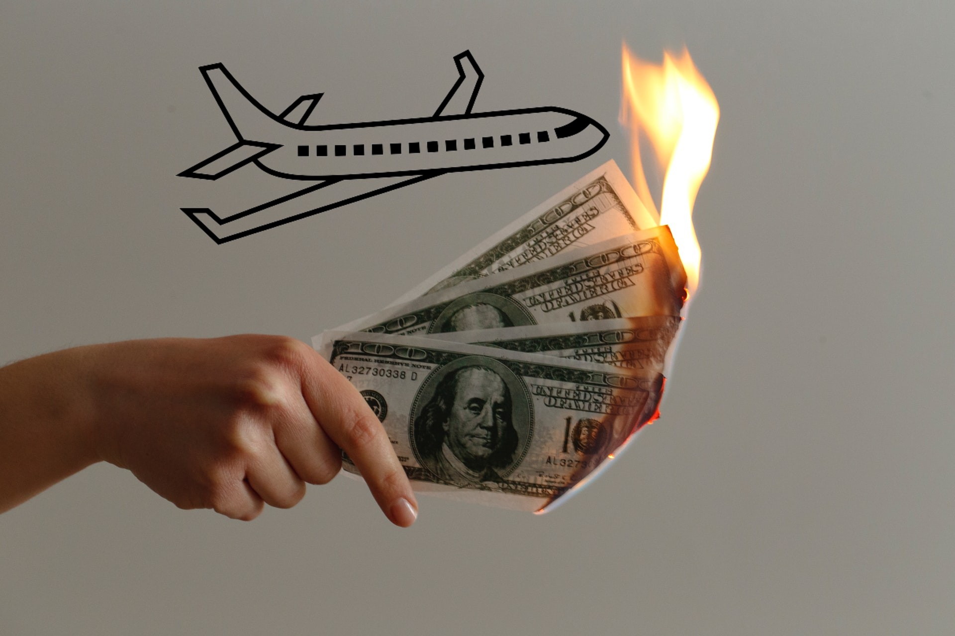 avión y mano con dólares en llamas