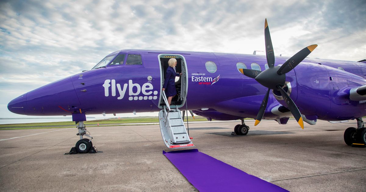 avión de Flybe en la pista, aeromoza en la puerta, junto a la escalerilla