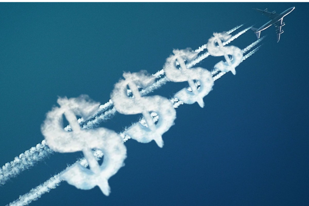 avión dejando trazas de humo blanco detrás, y símbolos de dólares en humo