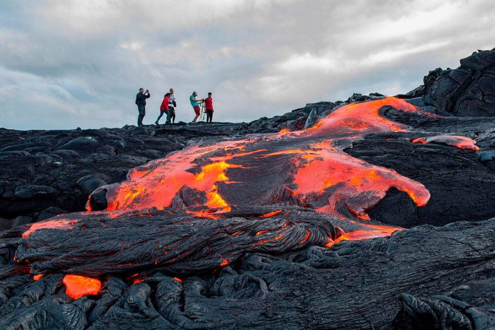 turistas en un volcán, río de lava en primer plano