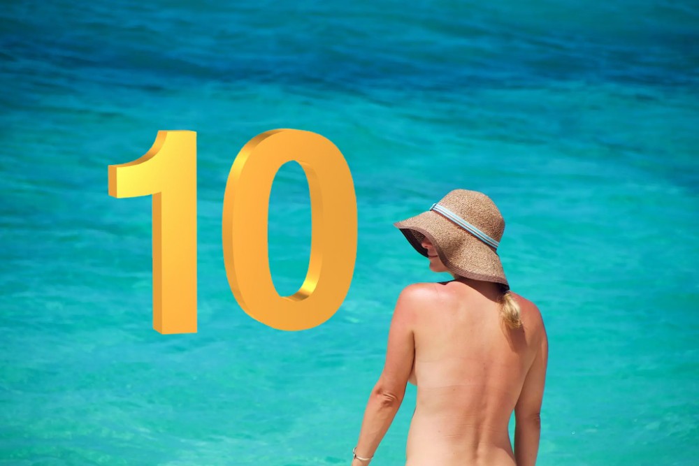 mujer de espalda con sombre en una playa y el nùmero 10 en dorado
