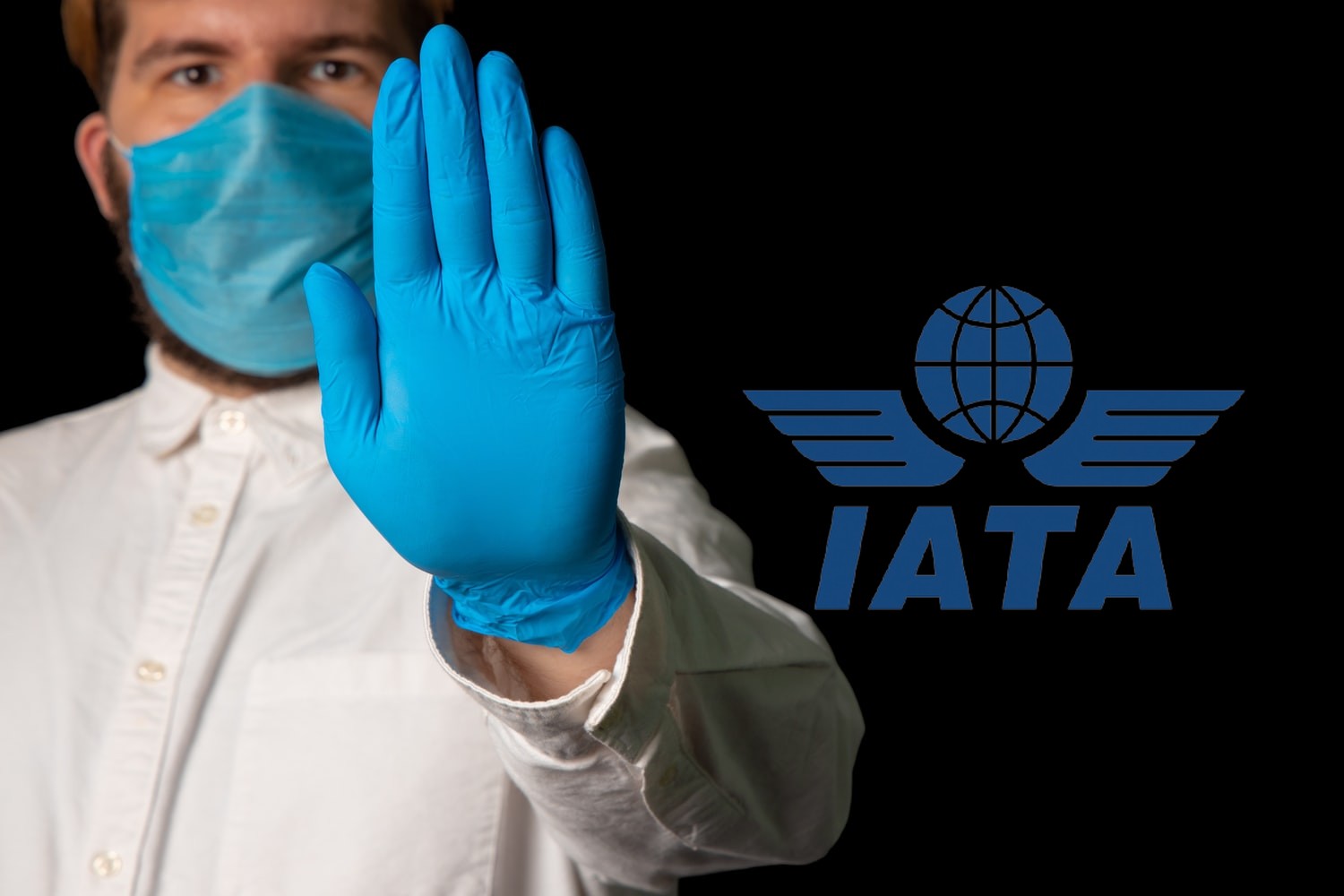 médico con guante azul y logo de la IATA
