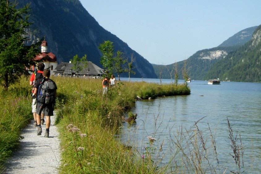 viajeros españoles caminando por un lago