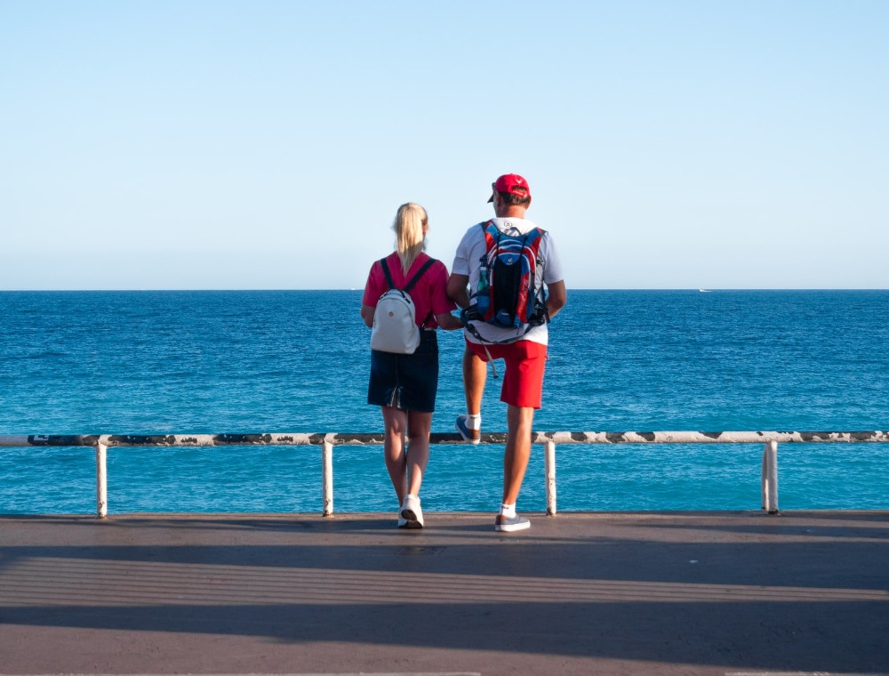 una pareja de turistas de espaldas, mirado al mar